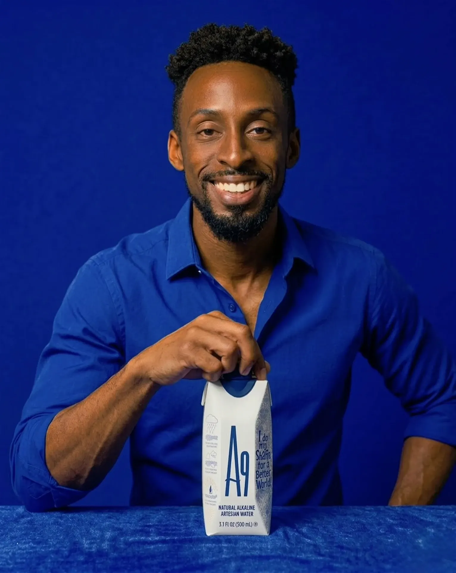 Man in blue opening an A9 alkaline water carton